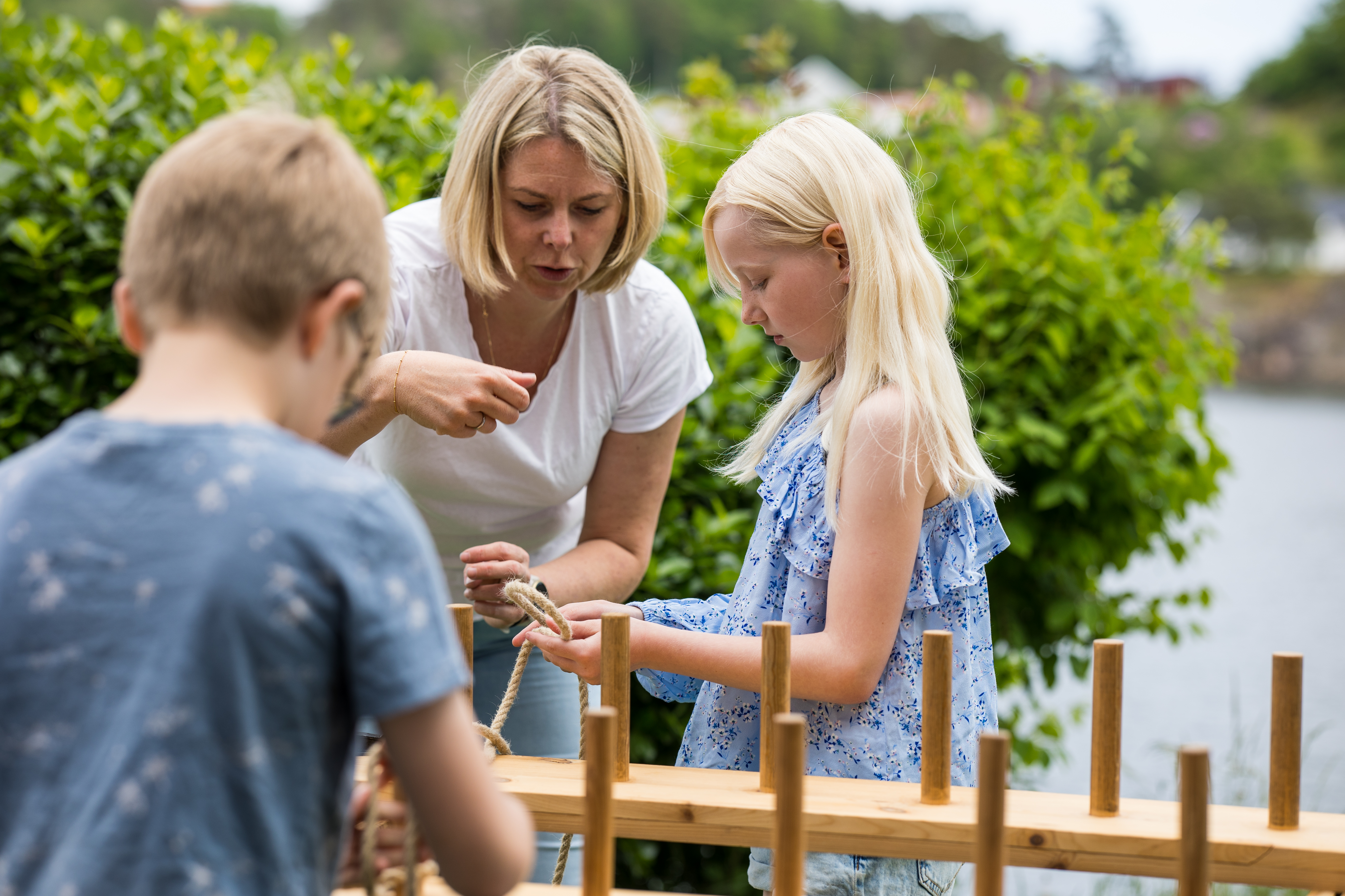 To barn og en voksen med tau og påler