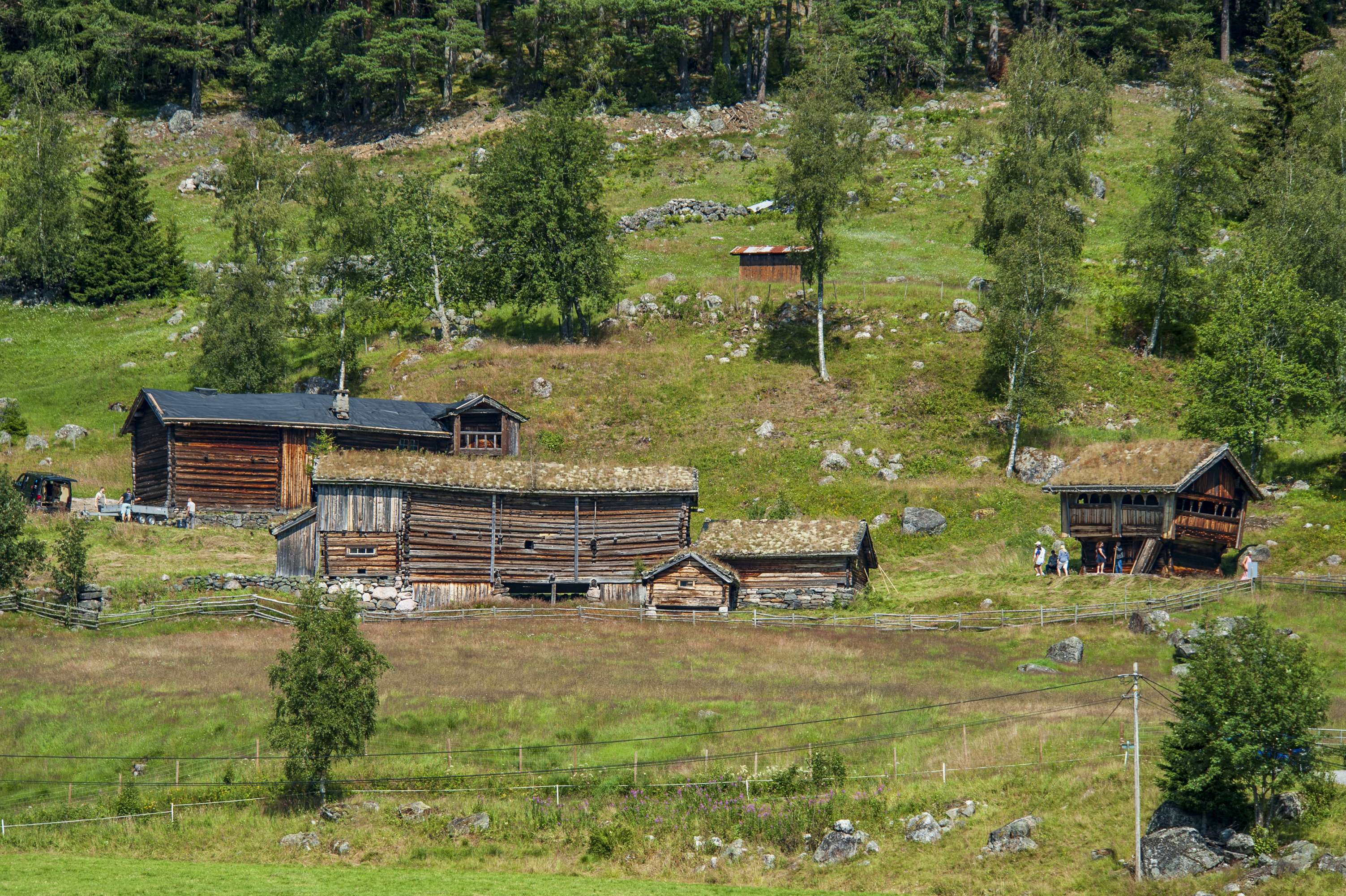 Gamle tømmerbygninger i landskap